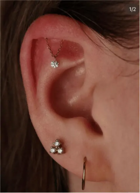 Ohr mit mehreren Piercings im oberen Knorpel